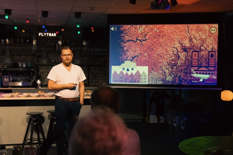 bildet viser en mann som presenterer en powerpoint på et lerret 